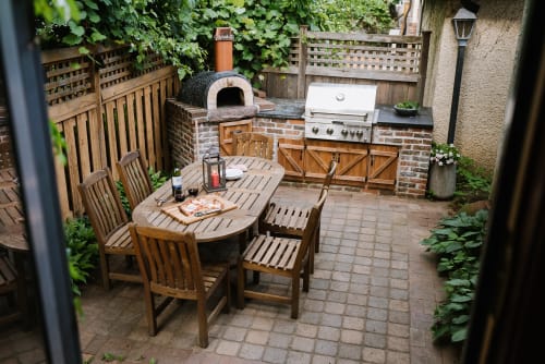 Your private outdoor kitchen awaits with a pizza oven and grill, perfect for memorable dining experiences under the leafy canopy.