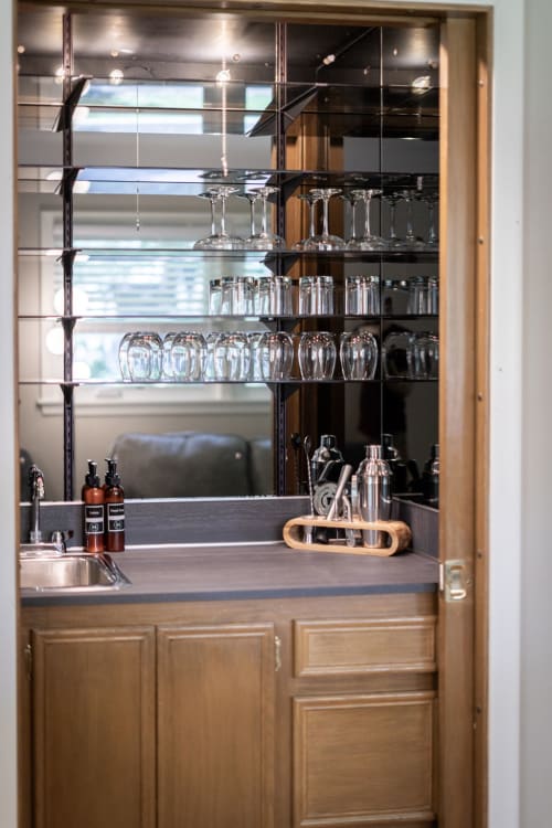 Your sophisticated wet bar awaits with gleaming glassware, cocktail shakers, and premium spirits perfectly organized for memorable evenings.