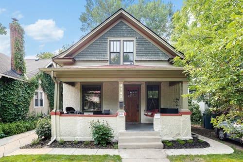 Charming Craftsman home with covered front porch and distinctive architectural details in a tree-lined neighborhood setting.