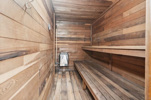 Unwind in your private wooden sauna, where warm cedar walls and tiered benches create the perfect retreat for deep relaxation.