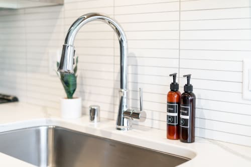 Prepare your meals with ease at the sleek kitchen sink, complete with premium amenities and elegant tile backsplash for your culinary adventures.