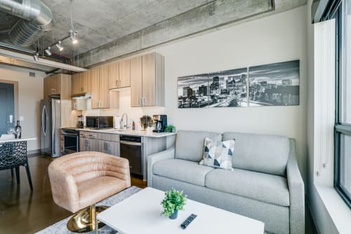 Relax in this sleek loft's open living space where modern comfort meets urban style—your perfect home base.