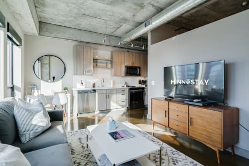 Relax in your modern loft with exposed concrete, stylish furnishings, and a fully equipped kitchen perfect for city living.