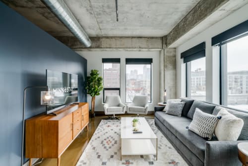 Unwind in your stylish loft with exposed concrete beams, modern furnishings, and stunning city views through floor-to-ceiling windows.