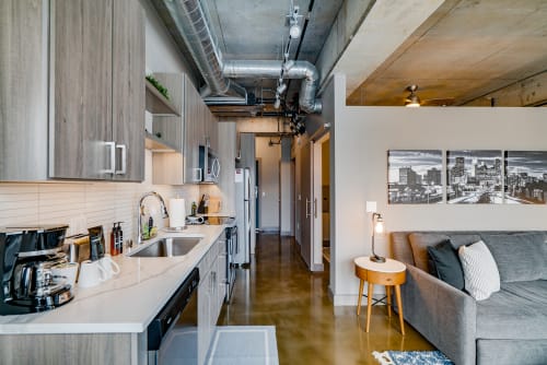 Your modern loft features exposed industrial ductwork, sleek kitchen appliances, and polished concrete floors for urban sophistication.
