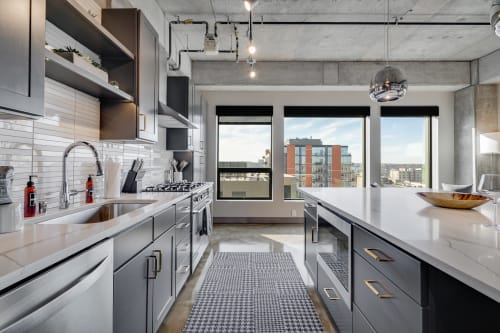 Cook with style in your sleek modern kitchen, featuring premium appliances and stunning city views through floor-to-ceiling windows.