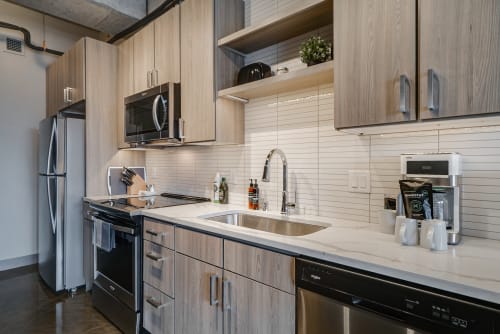 Your sleek modern kitchen features quartz counters, stainless appliances, and warm wood cabinetry—perfect for preparing memorable meals during your stay.