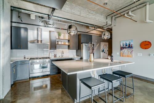 Cook in your modern industrial kitchen with sleek gray cabinets, stone countertops, and professional-grade appliances.