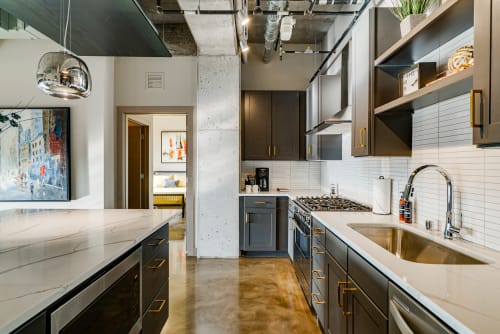 Cook gourmet meals in your sleek industrial kitchen featuring marble countertops, professional gas range, and stylish pendant lighting.