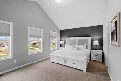 Drift off peacefully in your stylish bedroom featuring crisp white linens and built-in storage beneath the bed.