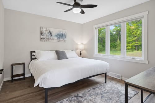 Drift off to sleep in your serene bedroom, where soft linens and peaceful forest views create the perfect retreat.