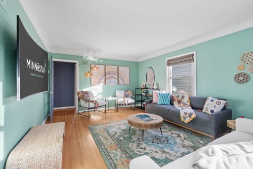 Relax in your stylish living space with soothing mint walls, cozy seating, and vibrant artwork creating the perfect atmosphere for unwinding.