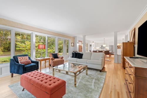 A bright and airy living room with large windows and cozy furnishings.